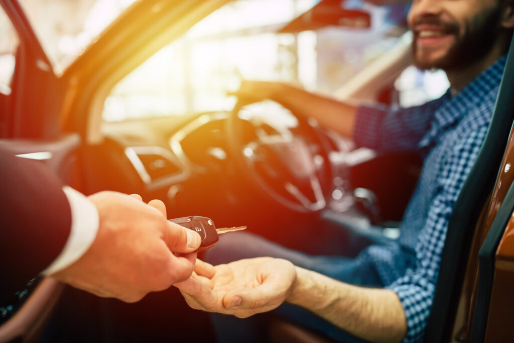 Man getting handed keys in car